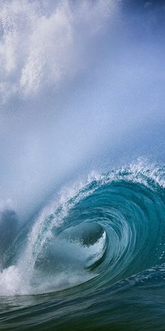 a man riding a wave on top of a surfboard in the ocean under a blue sky