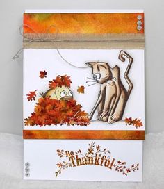 a card with an image of a cat and a fish in the fall leaves on it