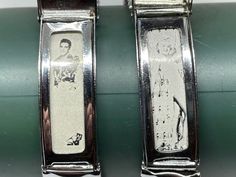 two silver bracelets with pictures on them