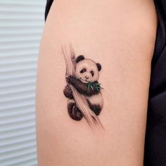 a panda bear tattoo on the back of a woman's arm