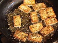 tofu being cooked in a wok with seasoning on the side and other ingredients