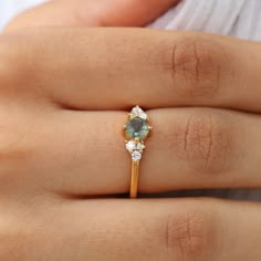 Dainty, yet powerful the Irene ring with round Moss Agate is one of those rings you put on and it instantly lifts you up and makes you feel good. There is something in the Moss Agate, the stone of abundance and feminine energy that makes this ring stand out and look beautiful on any lady. Together with side Moissanites, this is the perfect ring to treat yourself to. Details: Center stone Gemstone: Moss Agate Stone Shape: Round Measurements: 5mm Side stones Gemstone: Moissanite Shape: Round Measu Planet Ring, Engagement Ring Dainty, A Promise Ring, Pretty Engagement Rings, Green Gemstone Ring, Moss Agate Stone, Perfect Gift For Girlfriend, Agate Engagement Ring, Moss Agate Ring