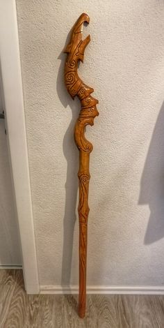 a wooden stick with an intricate design on it's end is leaning against the wall