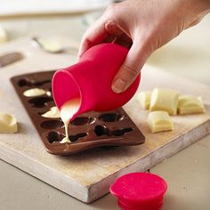 someone is pouring sauce into a muffin tray