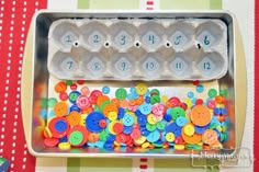 an egg carton filled with lots of colorful buttons