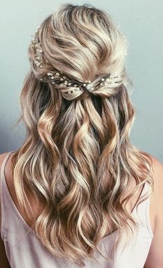 a woman with long blonde hair wearing a flowered headband and pearls in her hair