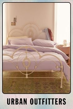 an image of a bed that is in the middle of a room with purple sheets and pillows