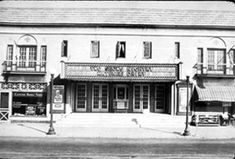 an old black and white photo of a building with two stories on the second floor