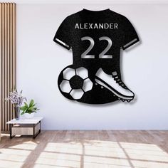 a wall mounted clock with a soccer jersey and shoes on it, next to a plant