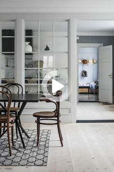 the dining room table is surrounded by chairs and glass doors that lead to an open kitchen