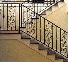 a staircase with wrought iron railing and handrail