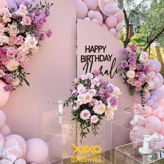 a birthday party with balloons and flowers on the wall