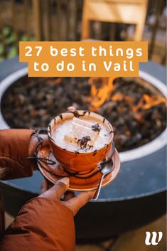 a person holding a drink in front of a fire pit with text overlay that reads, 27 best things to do in val