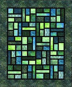 a green and blue quilt with squares in the center, on top of it is a square