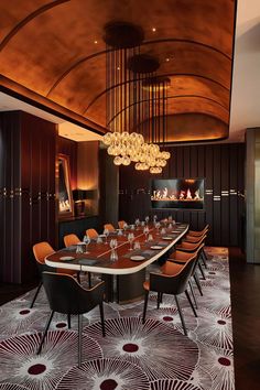 a dining room with a large table and chairs in front of a chandelier