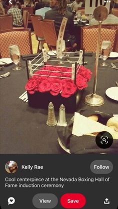 the table is set up for an event with red roses in a boxing ring on it