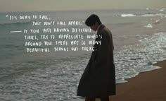 a man standing on top of a beach next to the ocean with a quote written in front of him