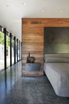 a bed sitting in the middle of a bedroom next to a wall with glass doors