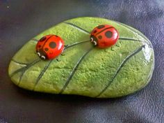 two ladybugs sitting on top of a green leaf