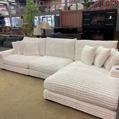 a couch made out of folded towels on display in a furniture store with other items behind it