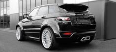 a black range rover parked in front of a building with its trunk open and the hood up