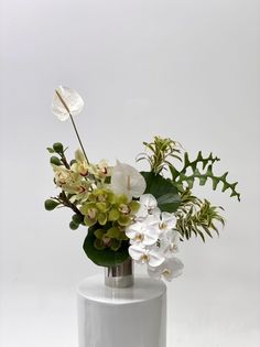 a white vase filled with flowers on top of a table