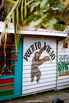 there is a sign on the side of a building that says puerto vieo with a sloth in it