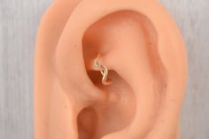 an ear is shown with a gold ring on it