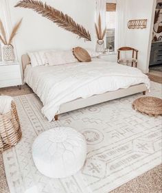 a bedroom with a bed, rugs and plants on the wall behind it in black and white