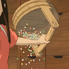 a woman holding a wooden barrel filled with sprinkles