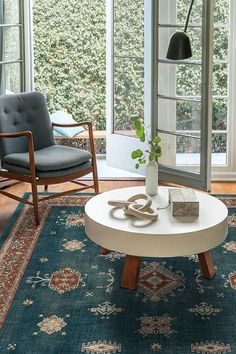 a living room filled with furniture and a rug on top of a hard wood floor