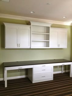 an empty room with white cabinets and drawers