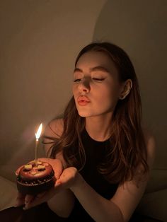 a woman holding a lit candle in her hand