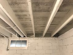 an unfinished room with exposed ceiling and brick walls