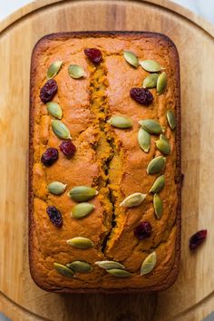 a loaf of pumpkin bread with cranberries and pistachios on top