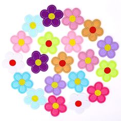 colorful felt flowers arranged in a circle on a white surface