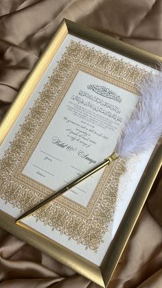 a certificate with a feather on top of it and a pen in front of it