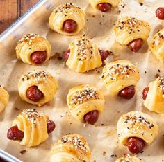 hotdogs wrapped in bread and topped with sesame seeds are ready to be eaten