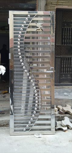 a large metal object sitting on top of a cement floor next to a building with doors