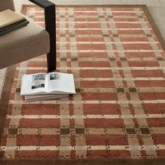 an open book sitting on top of a rug next to a chair