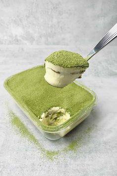 a spoon scooping green tea ice cream out of a container