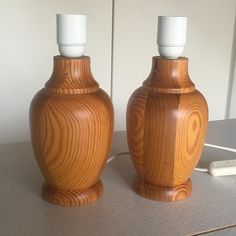 two wooden vases sitting on top of a table next to a white electric toothbrush