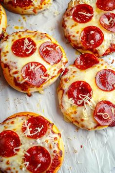 small pepperoni pizzas are sitting on wax paper