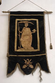 a black and gold wall hanging with an image of a woman holding a sceptula