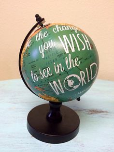 a green and white globe with words on it sitting on top of a wooden table