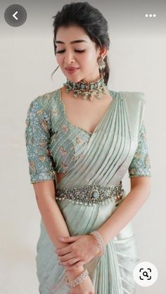 a woman in a green sari with jewelry on her neck