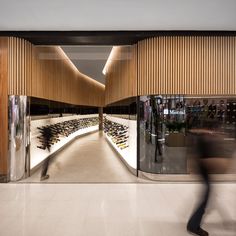 a blurry photo of a person walking past a wine store with many bottles on the shelves