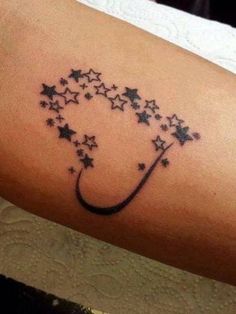 a woman's arm with stars on it and the word love written in black ink