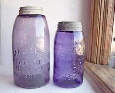 two purple mason jars sitting next to each other