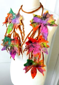 a white mannequin with colorful leaves on it